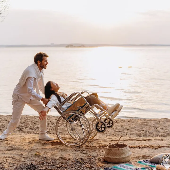 A support worker and a participant enjoying the water's edge at sunset on the Mornington Peninsula